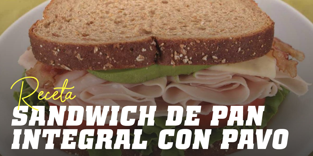 Sandwich de pan integral con pavo, lechuga y tomate y un zumo de naranja