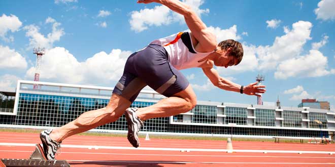 Sprinter startet aus dem Startblock auf einer Leichtathletikbahn während eines Sprinttrainings.