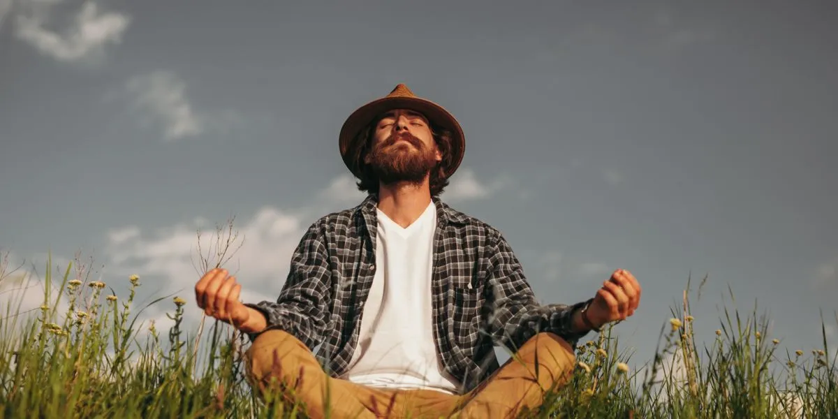 Hombre con barba meditando en el campo Hombre con barba meditando en el campo