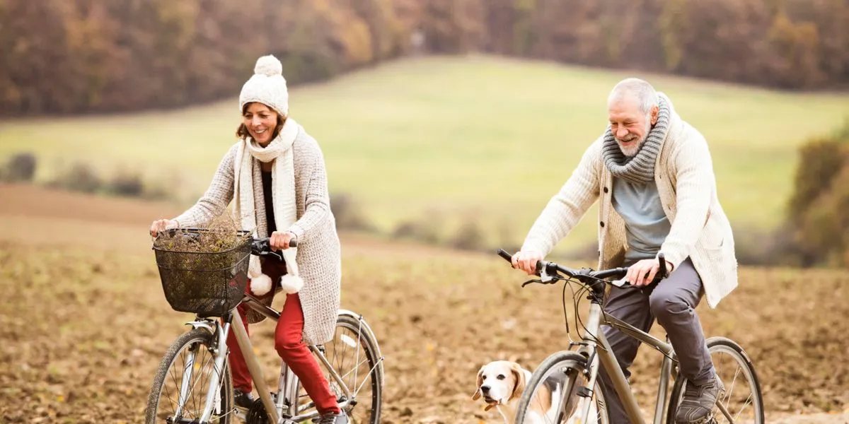 Pareja de jubilados montando en bicicleta por el campo