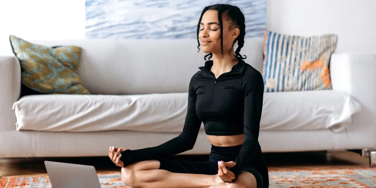 Chica practicando meditación sentada en su salón