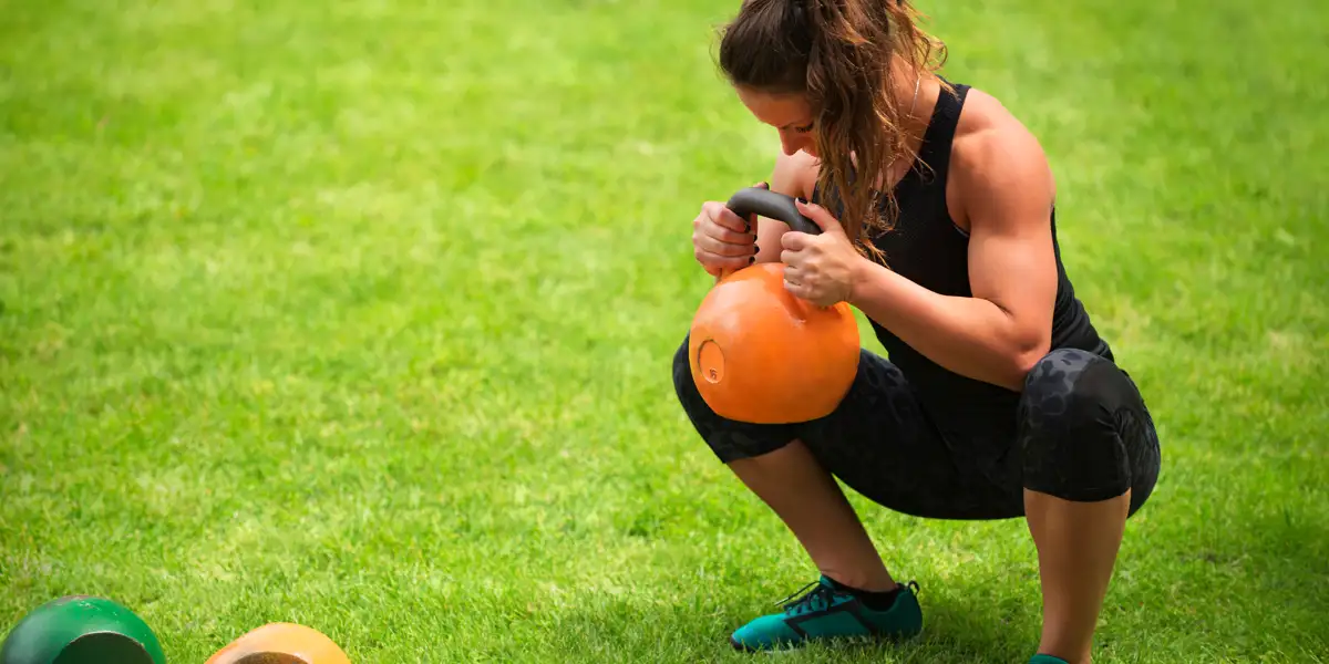 Fille sportive s’entraînant avec des kettlebells Fille sportive s’entraînant avec des kettlebells