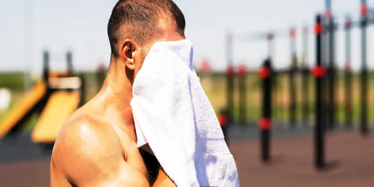 Personne sportive s’essuyant le visage avec une serviette Personne sportive s’essuyant le visage avec une serviette