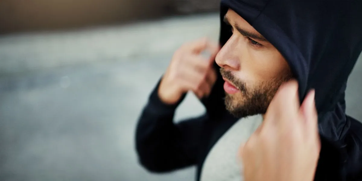 Hombre con capucha concentrado antes de salir a correro