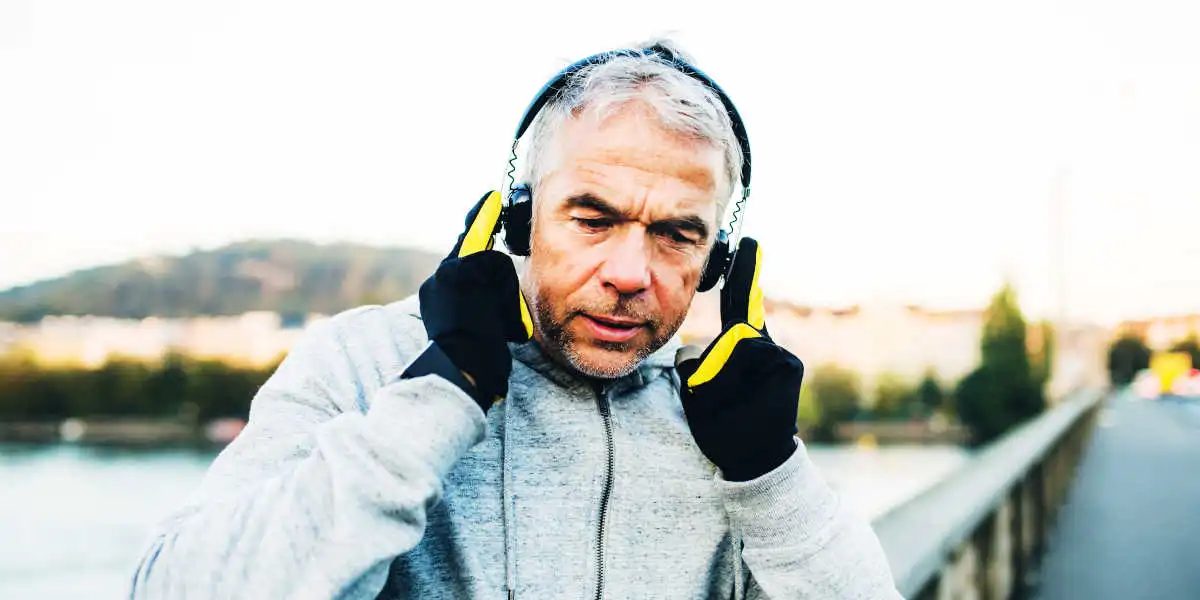 Uomo di mezza età che cammina ascoltando musica