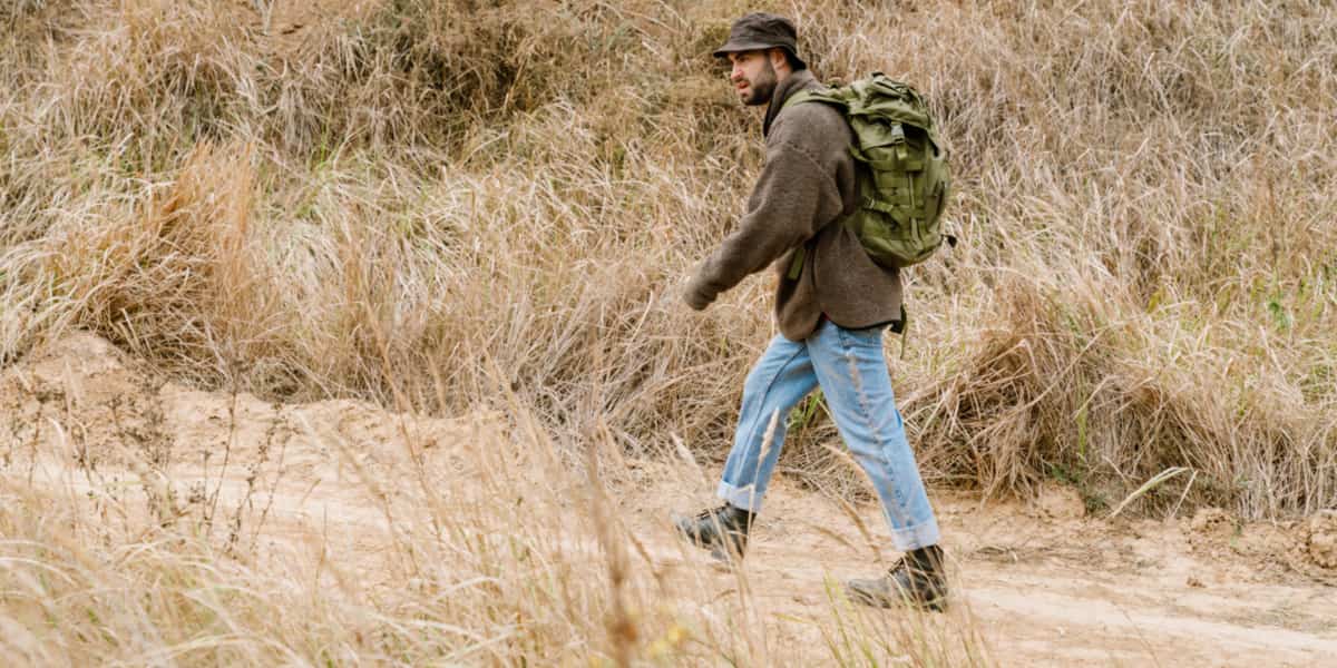 Hombre caminando con mochila con peso por terreno con desnivel Tipos de lastres o pesos