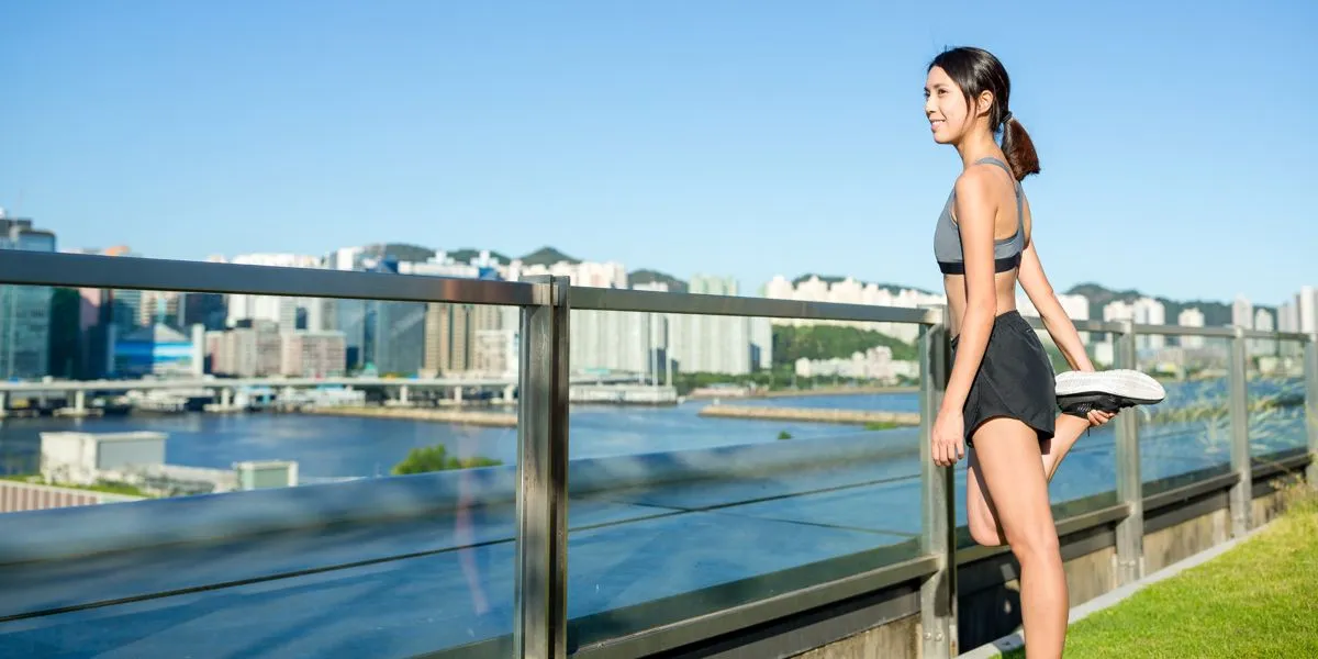 Chica realizando estiramientos después de correr Chica realizando estiramientos después de correr