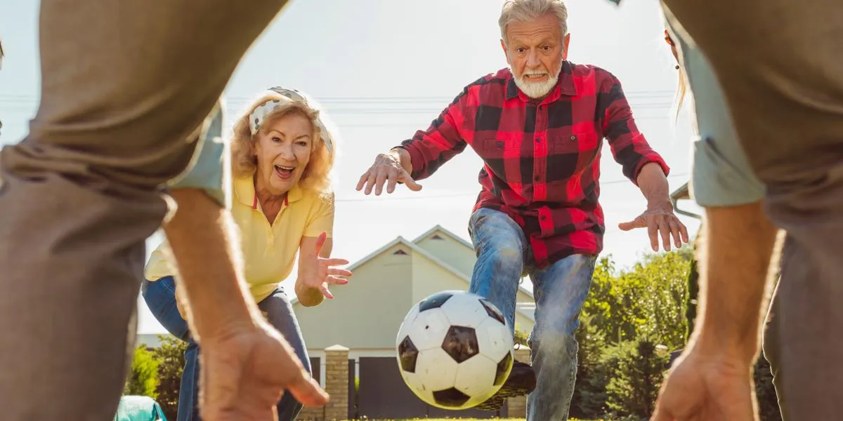 Adultos mayores jugando con balón de fútbol