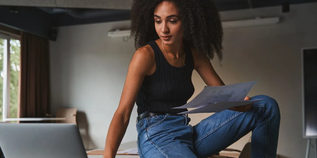 Mujer con rizos realizando un descanso durante el trabajo para mantener el rendimiento mental Mujer con rizos realizando un descanso durante el trabajo para mantener el rendimiento mental