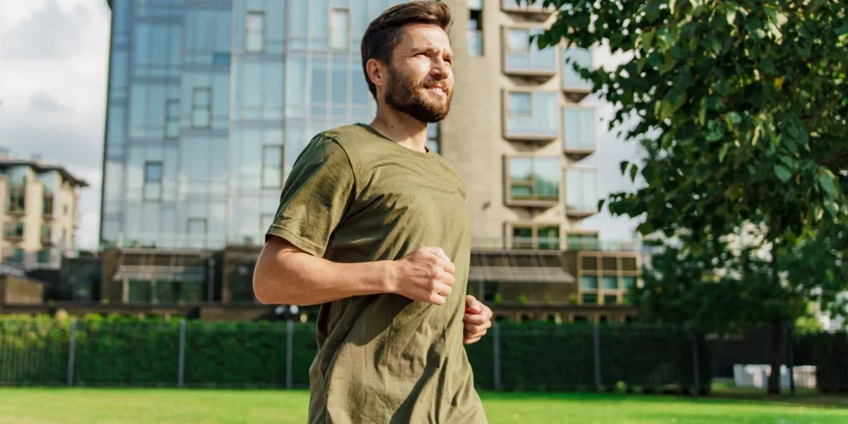 Hombre con barba corriendo por la ciudad como parte de su rutina diaria para mantener la energía Hombre con barba corriendo por la ciudad como parte de su rutina diaria para mantener la energía