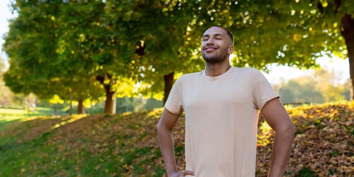 Joven corredor disfrutando de la carrera por medio del parque