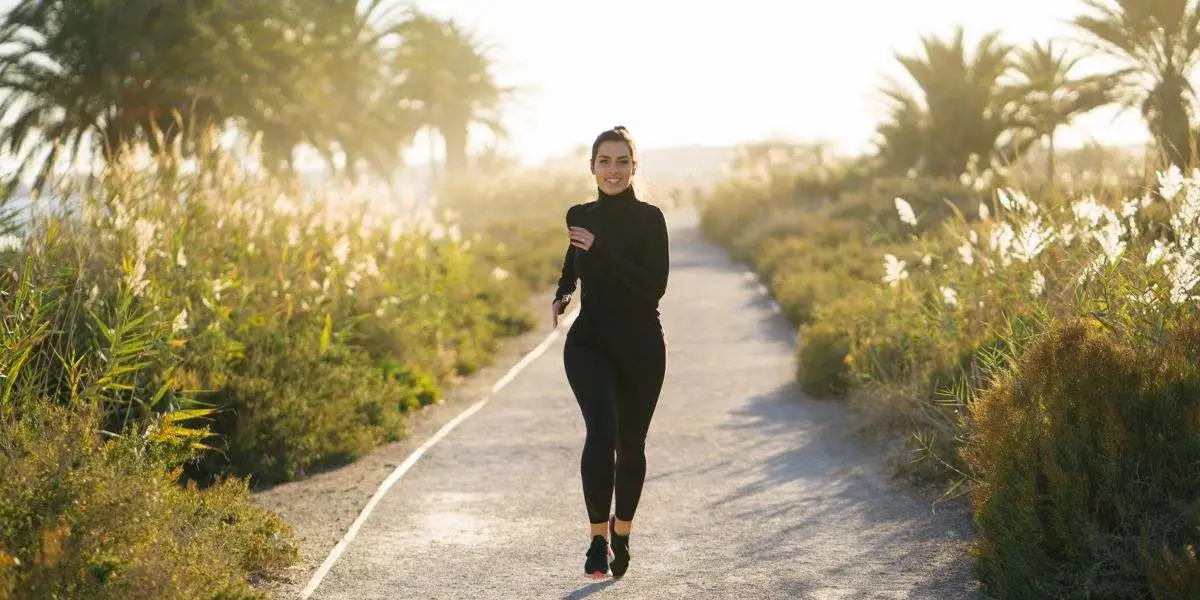 Corredora por un camino rodeada de un entorno natural