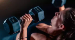 Mujer realizando press de pecho con mancuernas