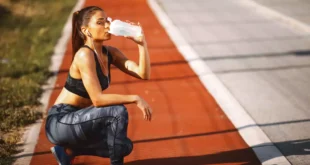 Chica runner bebiendo agua en carril bici