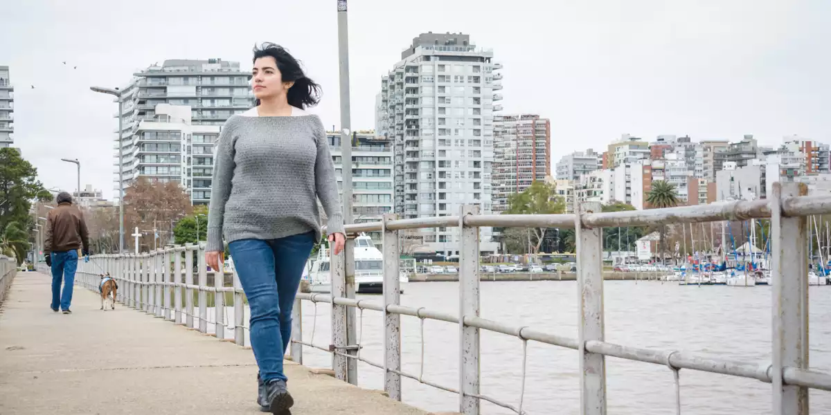 Mulher a caminhar pelo cais