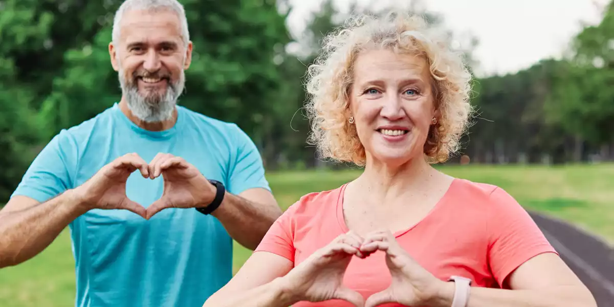 Coppia senior che fa il gesto del cuore con le mani