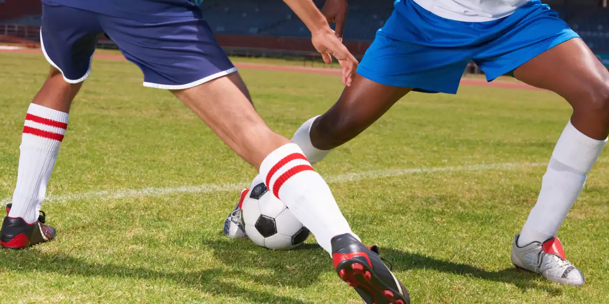Dois jogadores de futebol a driblar